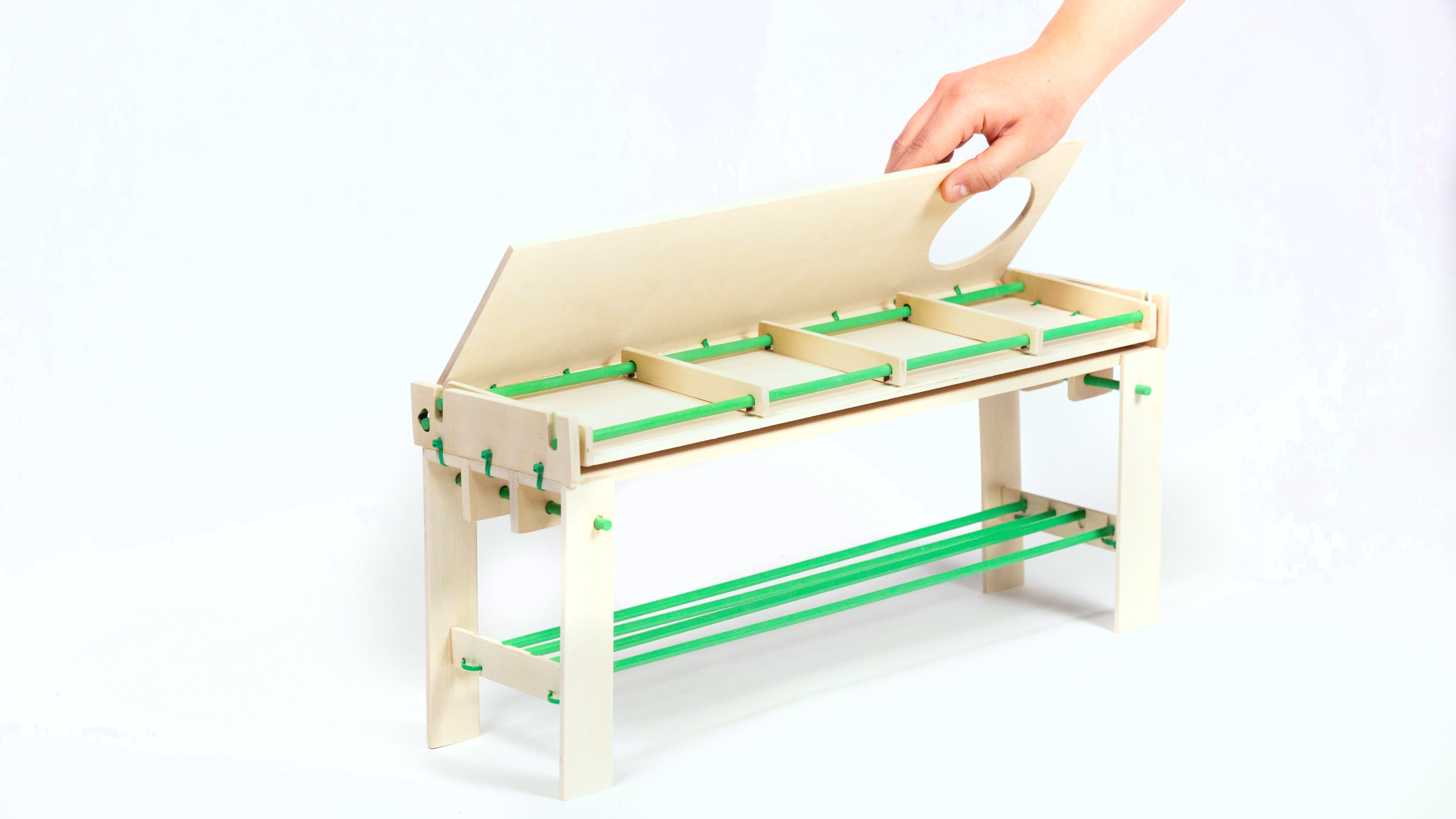 Hand lifting the hinged display surface of the [de]construct + [re]configure produce stand model